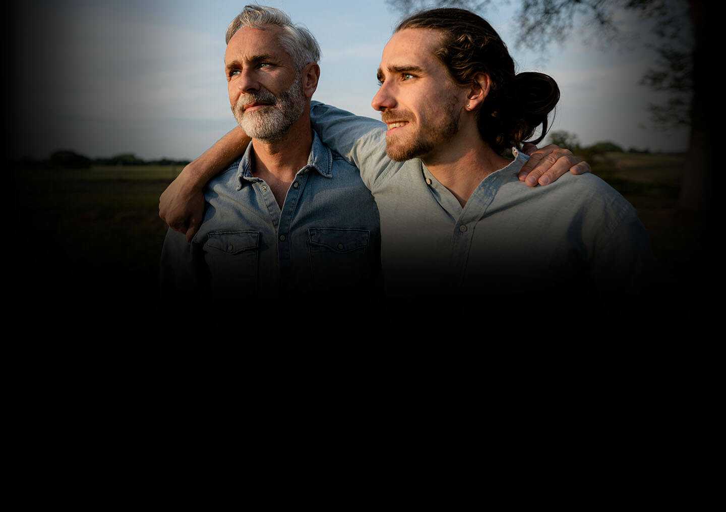 Pai e filho com os braços ao redor dos ombros um do outro